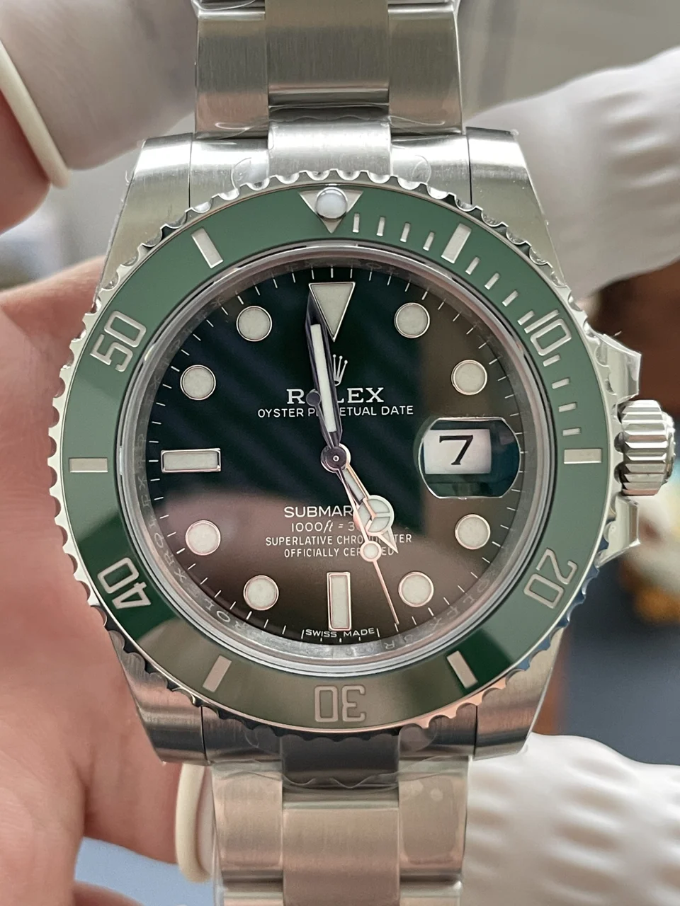 Photographie source en gros plan d’une montre réplique à lunette verte